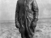 A World War I-era aviator wears a leather flight suit, boots and helmet along with gloves.  As open-cockpit aircraft flew increasingly higher, aviators required better protective gear to protect them against the cold.
